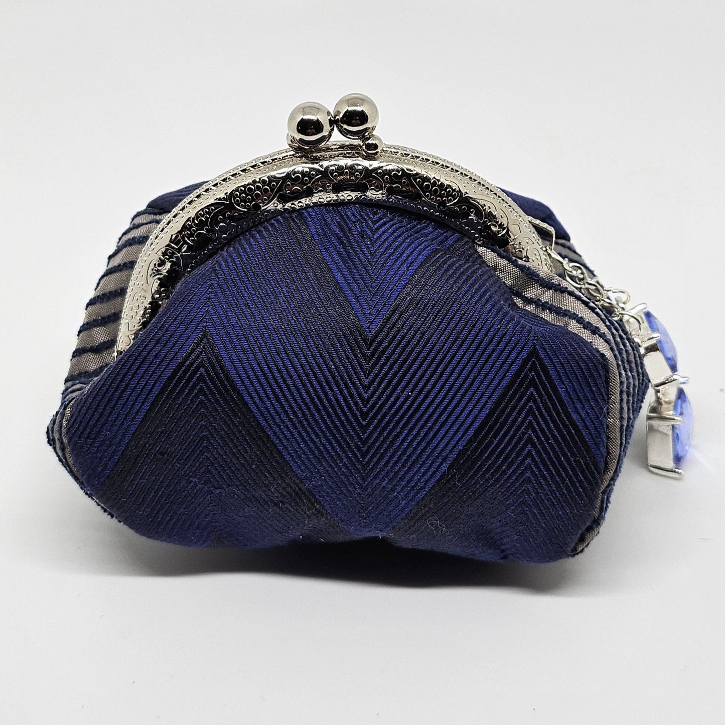 Front view of Navy chevron print kiss clasp coin purse with silvery blue jewel charm