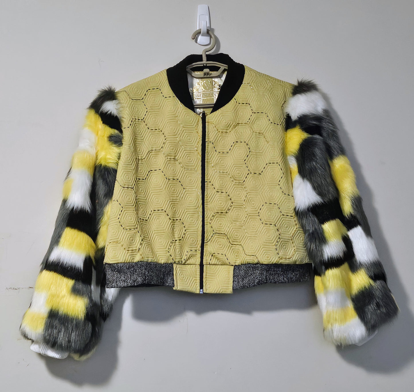 Front View of Hand embroidered honeycomb print textured cropped bomber jacket with multi-coloured fur sleeves.