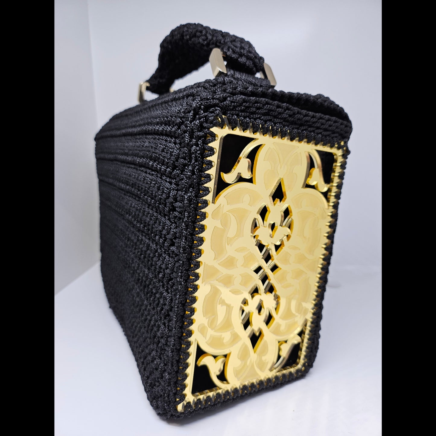 Side view of Structured black crochet handbag with custom made laser cut acrylic sides
