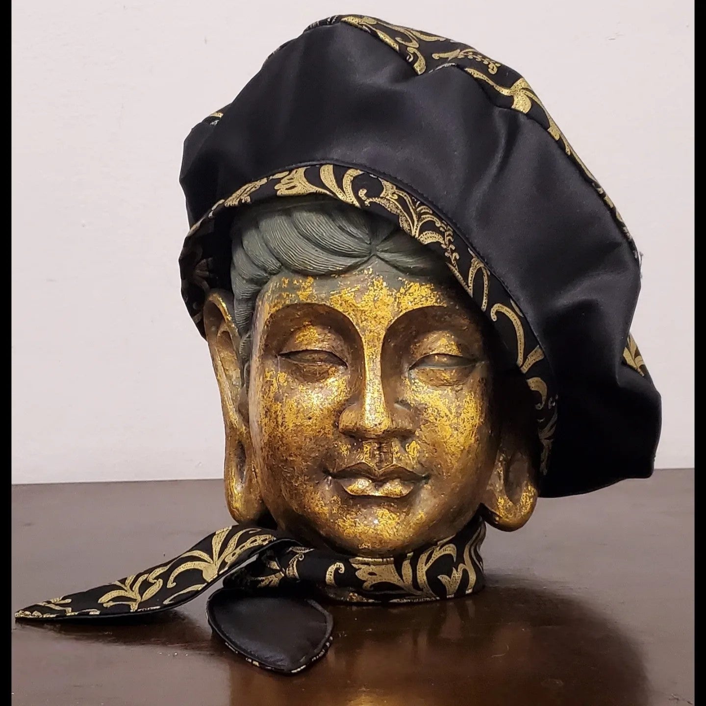 Black and gold damask printed beret with bow detail and matching scarf on mannequin head