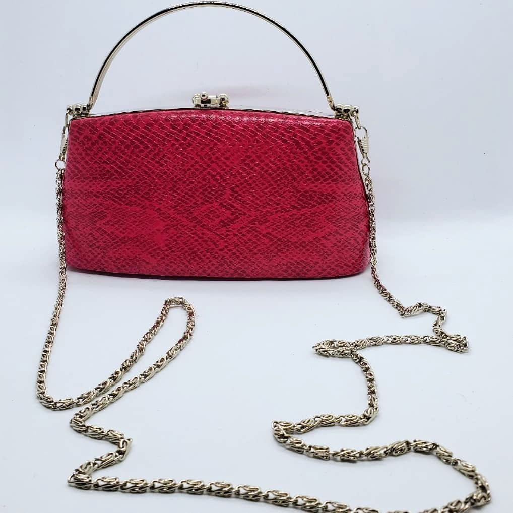 front view of hot pink snakeskin print handbag with silver crossbody chain