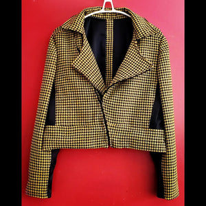 Front view of yellow and black houndstooth cropped moto jacket on red background