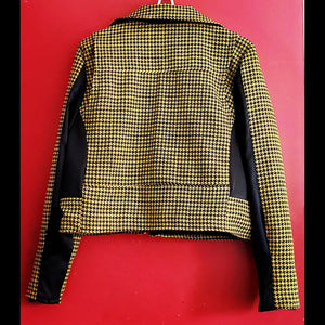 Back view of yellow and black houndstooth cropped moto jacket on red background