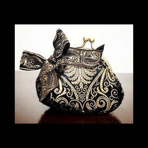 Front view of platinum and black paisley brocade coin purse with matching paisley bow accent