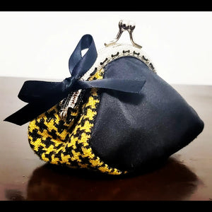 side view of Yellow and black hounds-tooth kiss clasp coin purse with bow