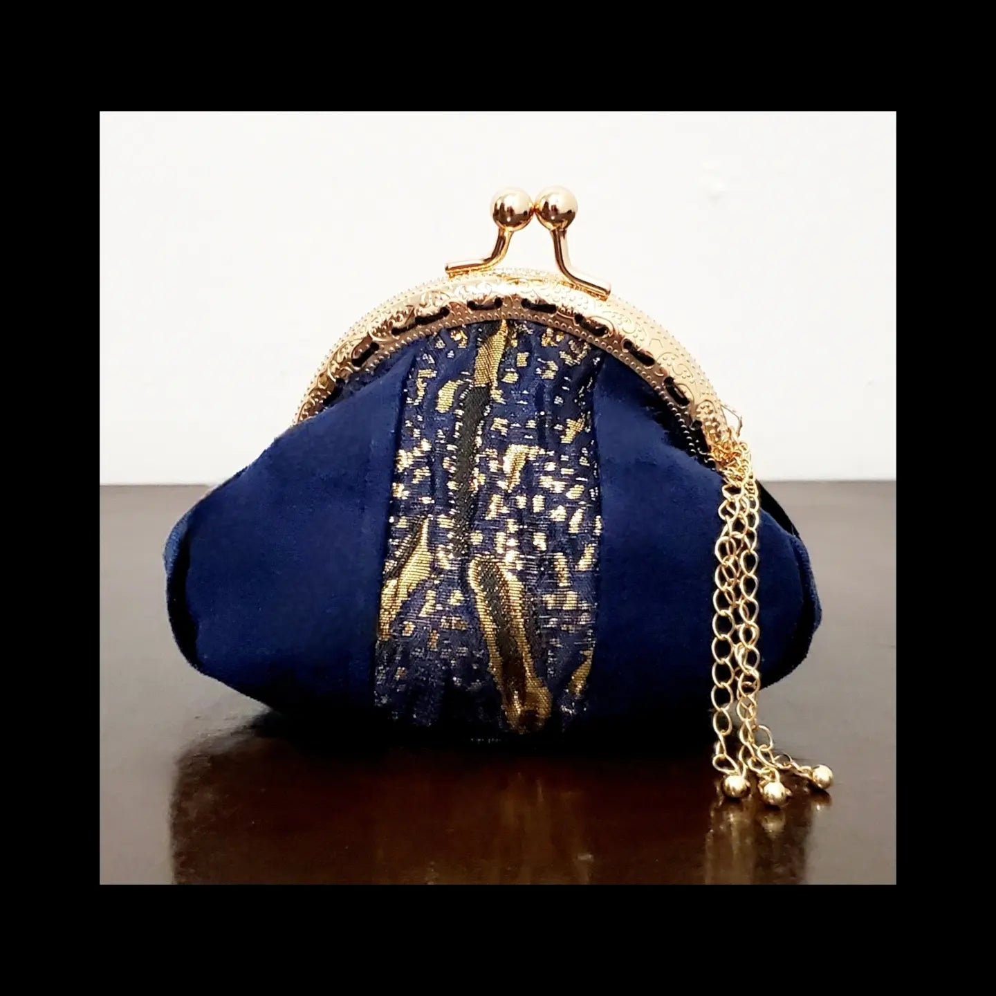 Back view of Blue and gold kiss clasp coin purse with gold tassel