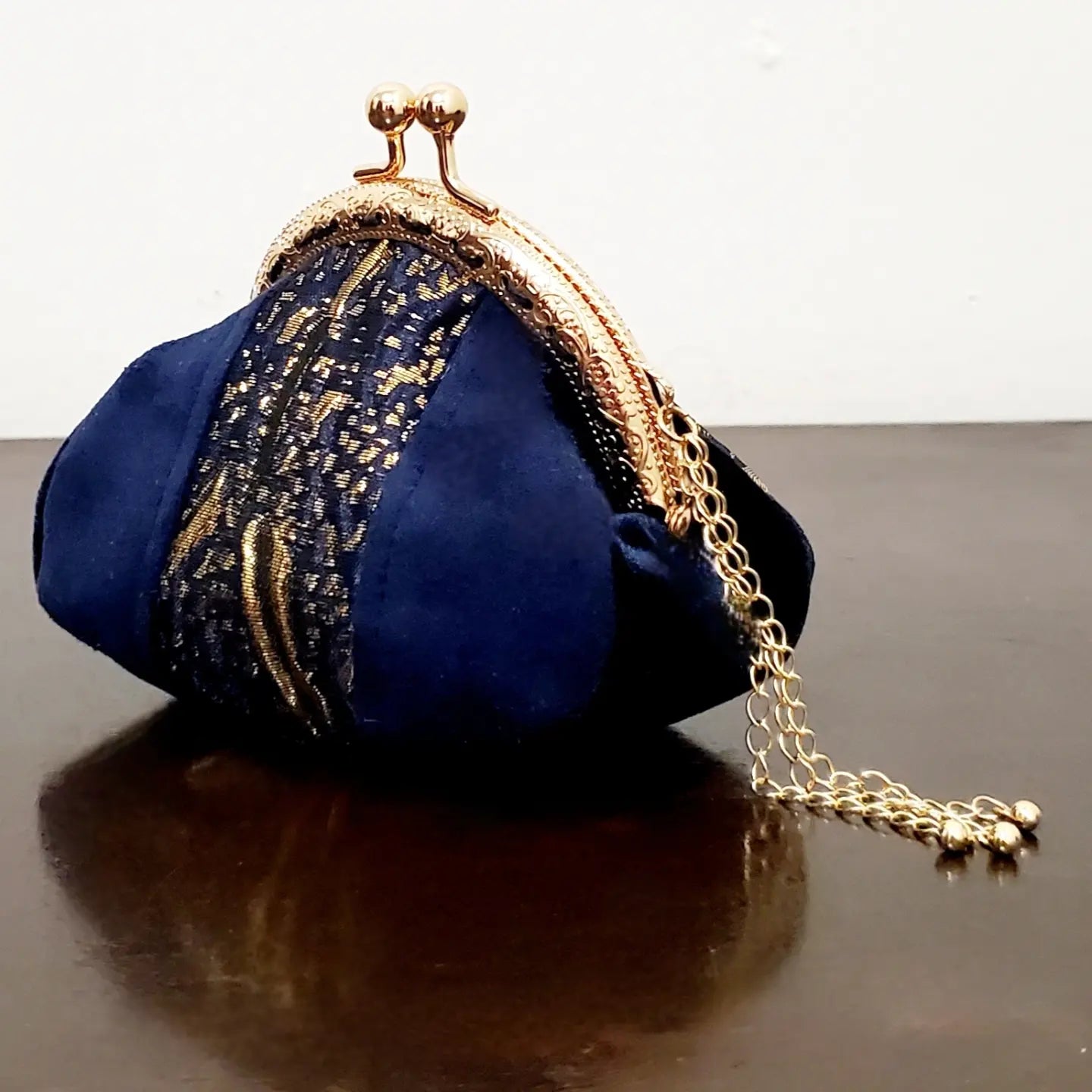 side view of Blue and gold kiss clasp coin purse with gold tassel