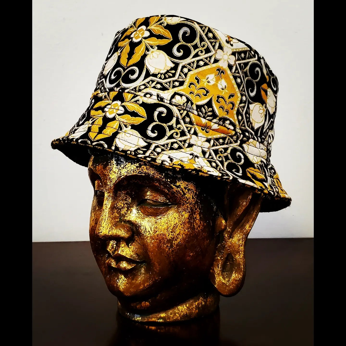 Side view of Reversible black and yellow printed bucket hat