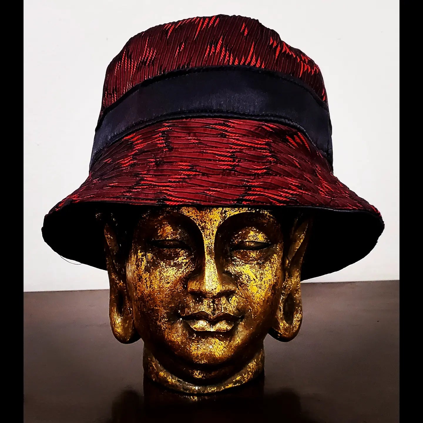 Front view of reversible red and black brocade bucket hat
