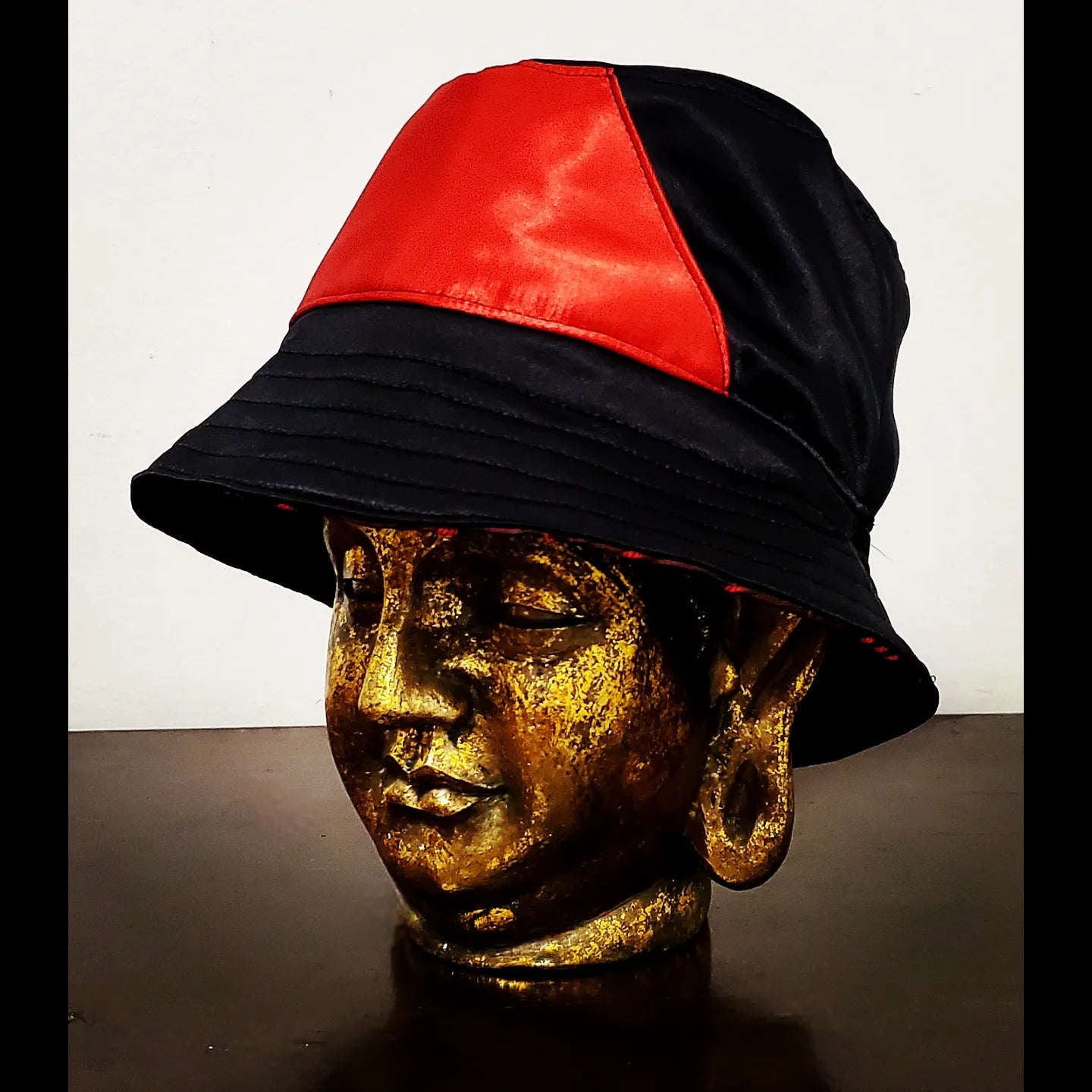 Reversed side view of reversible red and black brocade bucket hat