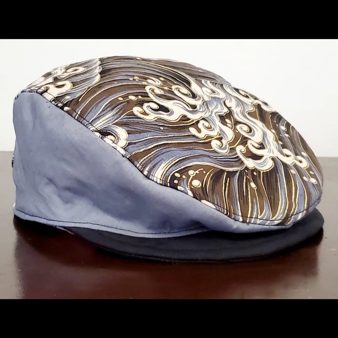 Side view of Grey and gold wave printed flat cap