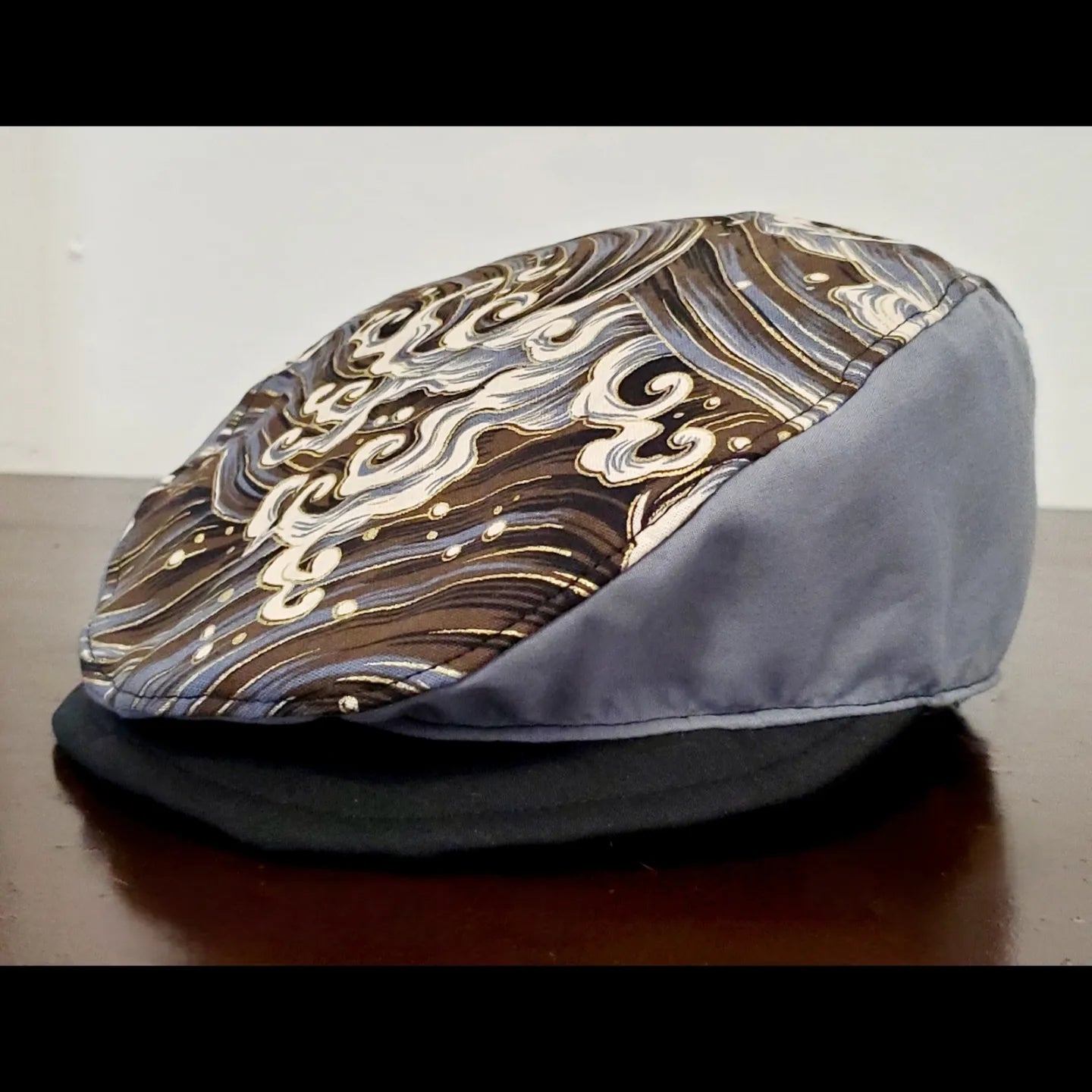 Left side view of Grey and gold wave printed flat cap