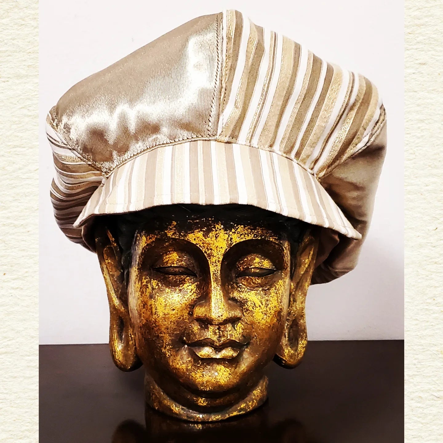 Front view of Gold and Ivory striped newsboy hat on mannequin head
