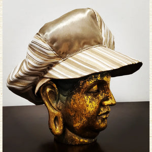 left side view of Gold and Ivory striped newsboy hat on mannequin head