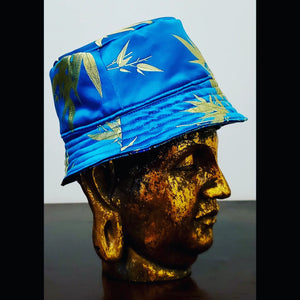 Side view of Teal blue reversible leaf and peacock printed bucket hat