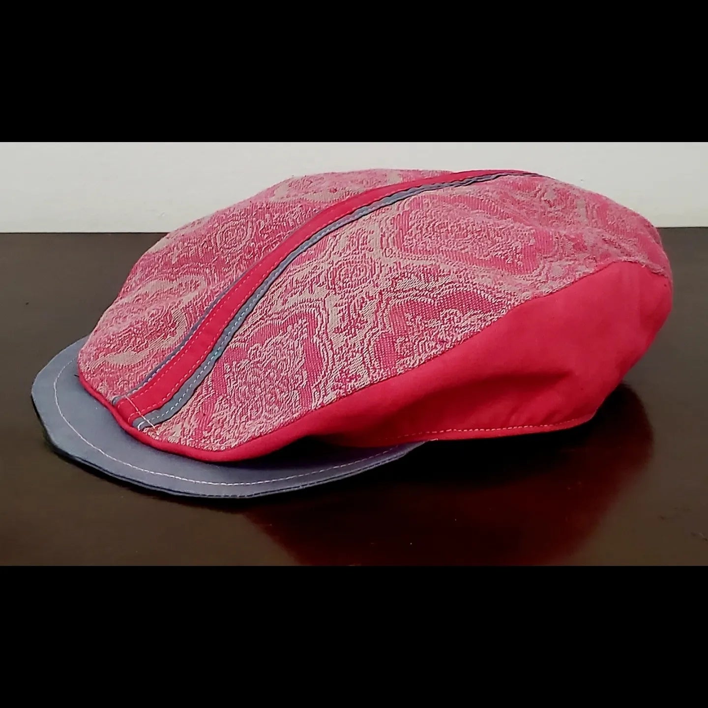 Side view of Pink and grey brocade print flat cap