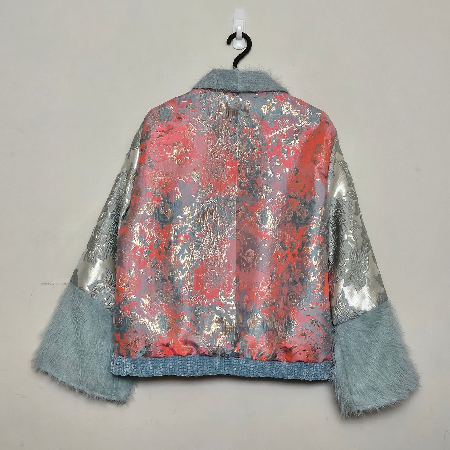 Back view of Coral and mint jacket with fringe cuffed sleeves