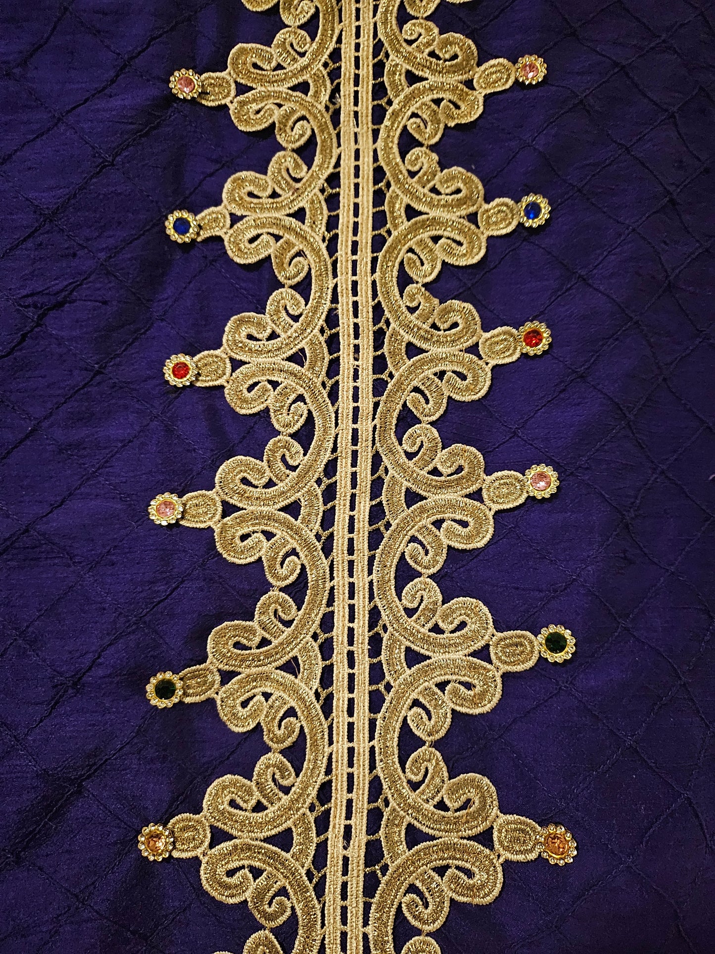 close up view of back details of Rhinestone encrusted purple silk bomber jacket with gold lace accents
