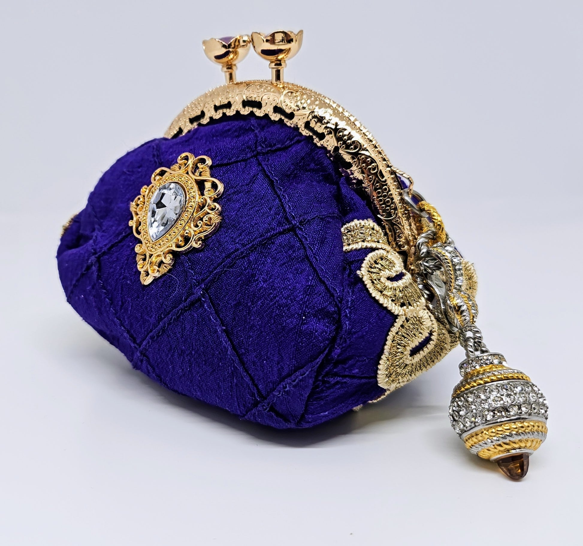 Side view of Pintuck purple silk kiss clasp coin purse decorated with rhinestone filigree accents