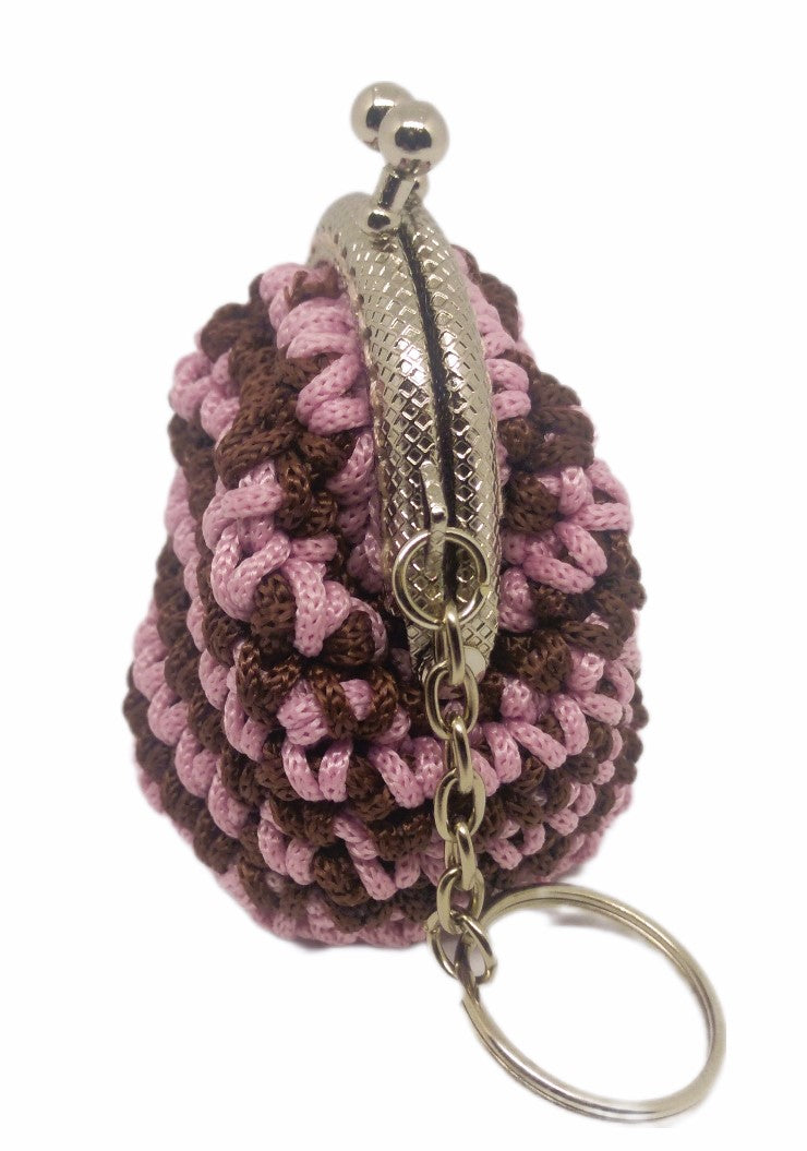 Side view of variegated pink and brown crochet coin purse keychain with silver kiss clasp frame.