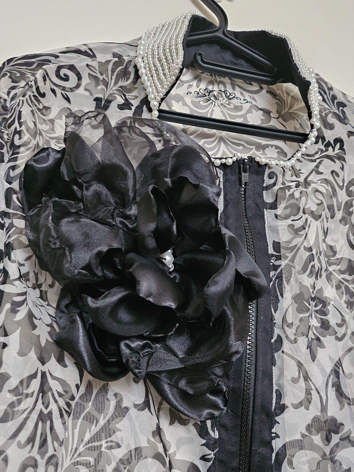 close up view of details of Sheer damask print bomber jacket with pearl and floral accents