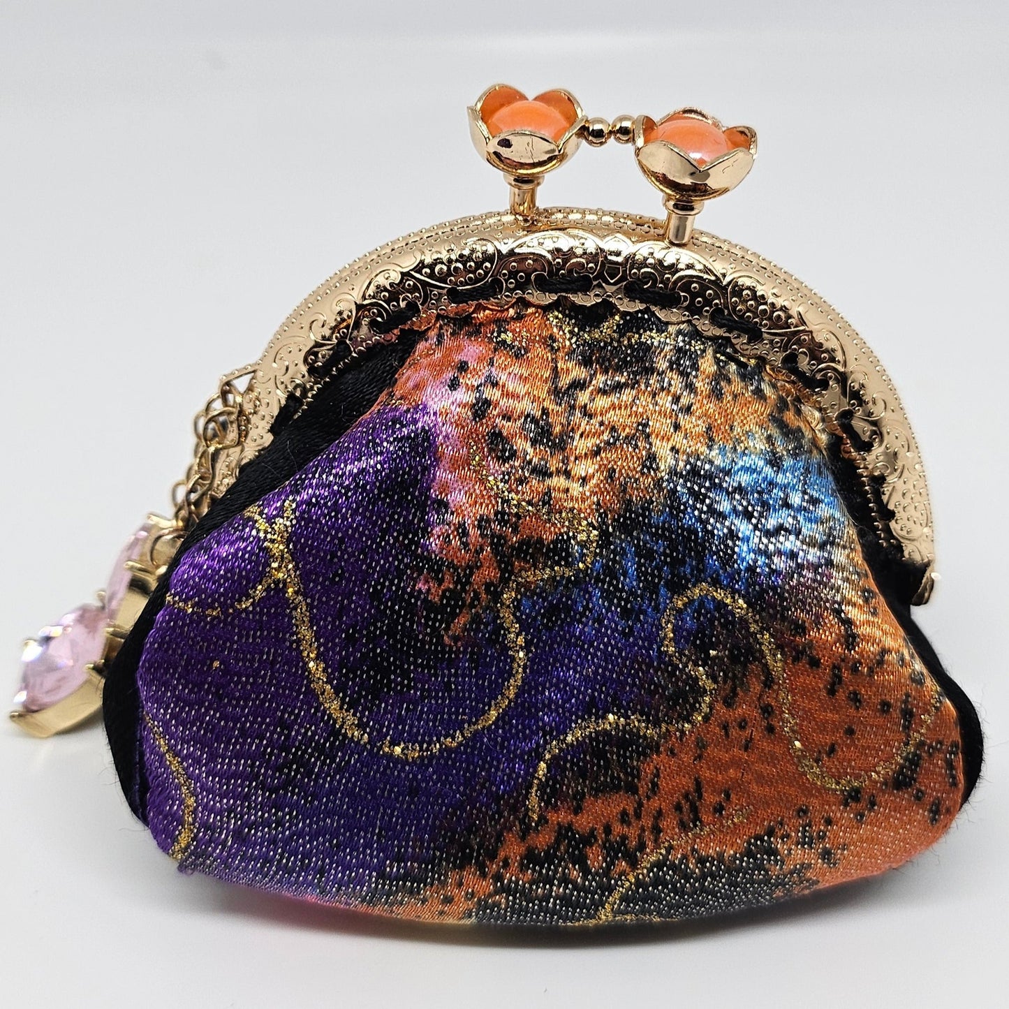 Front view of Metallic rainbow splash print kiss clasp coin purse with pink jewel charm