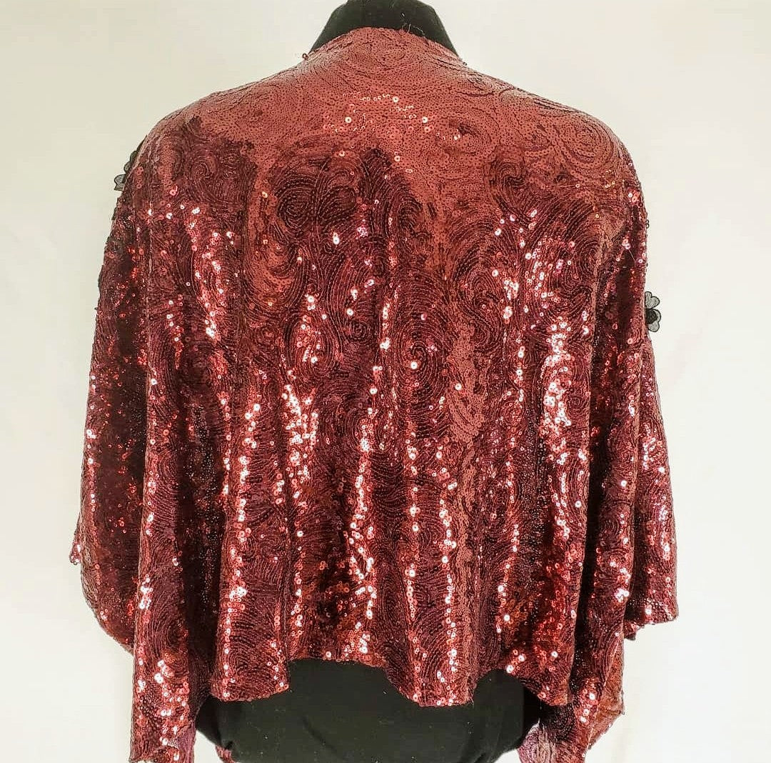 back view of Burgundy sequin kimono jacket with black embroidered shoulders on mannequin
