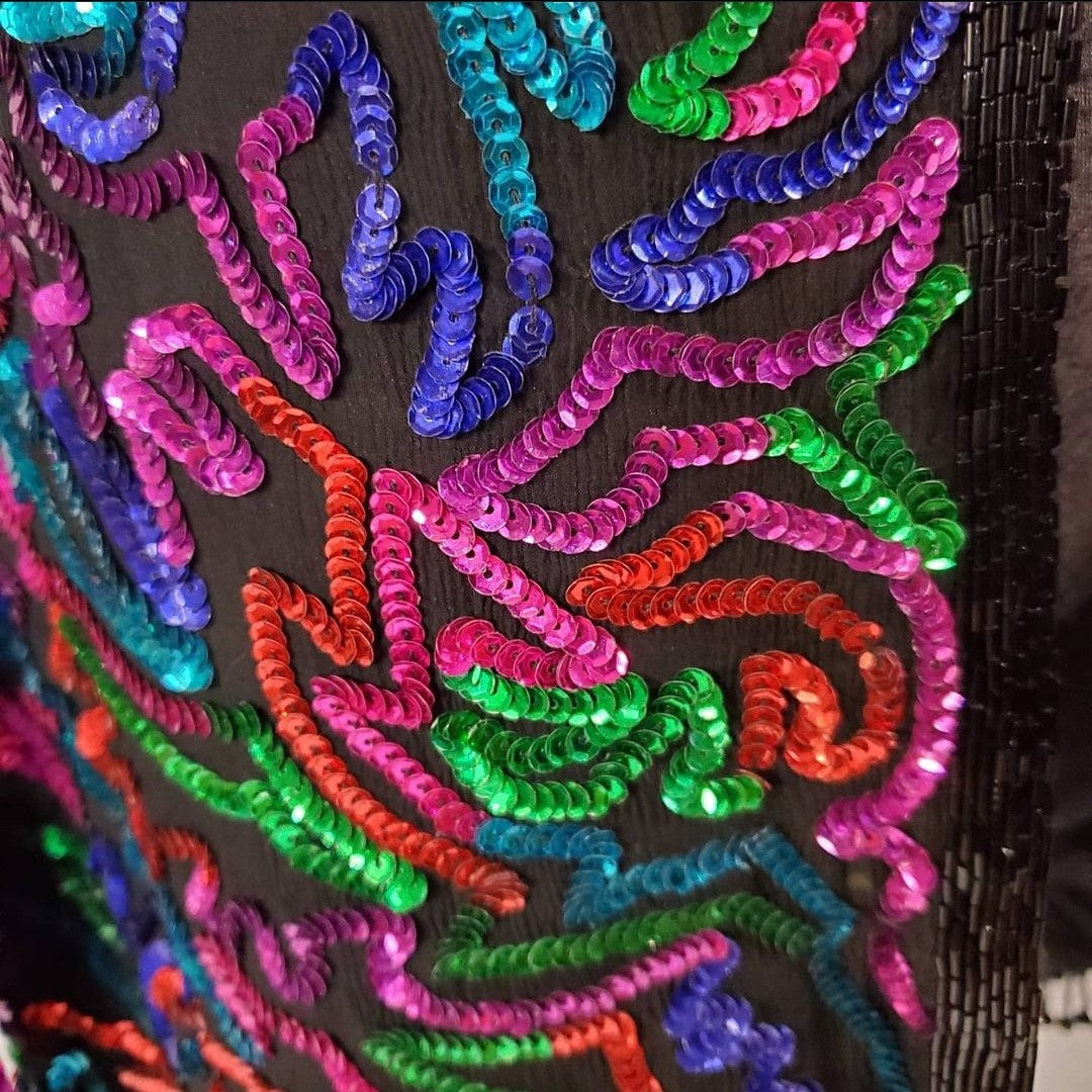 close up front view of Rainbow sequined jacket dress with fringe details