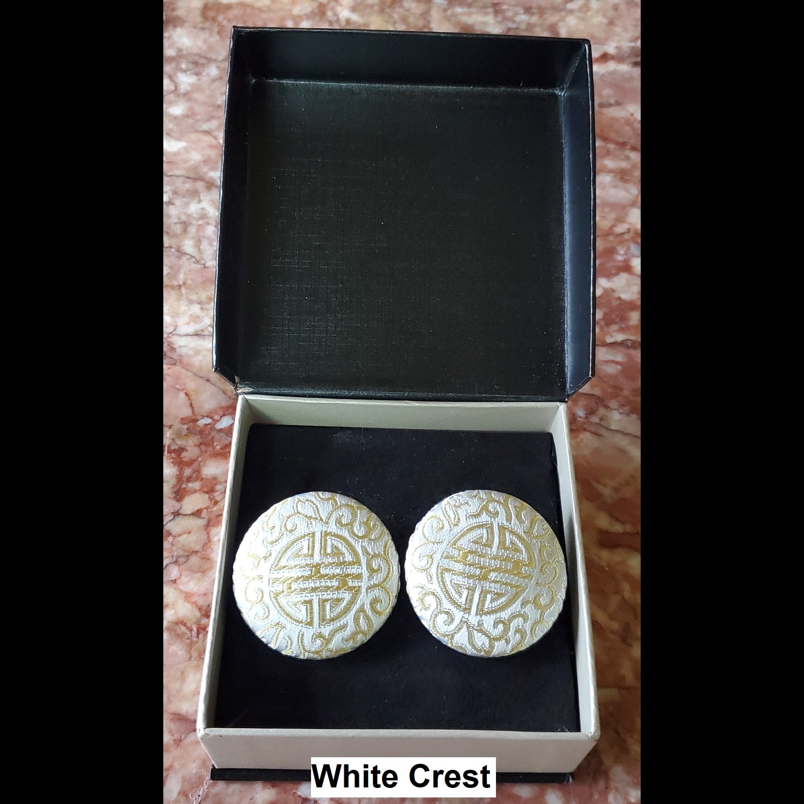 White crest print button earrings in jewelry box