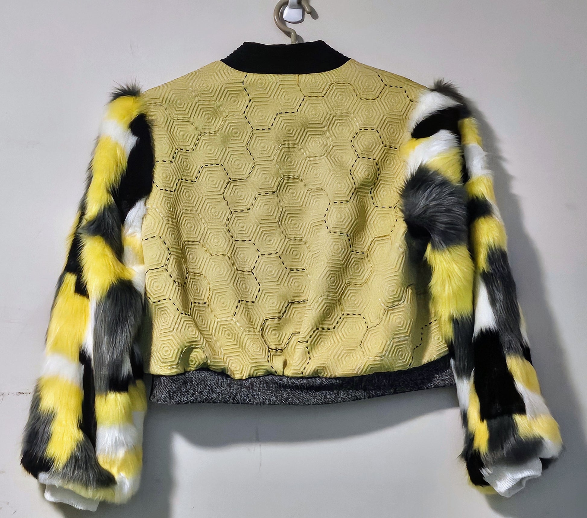 Back view of Hand embroidered honeycomb print textured cropped bomber jacket with multi-coloured fur sleeves.