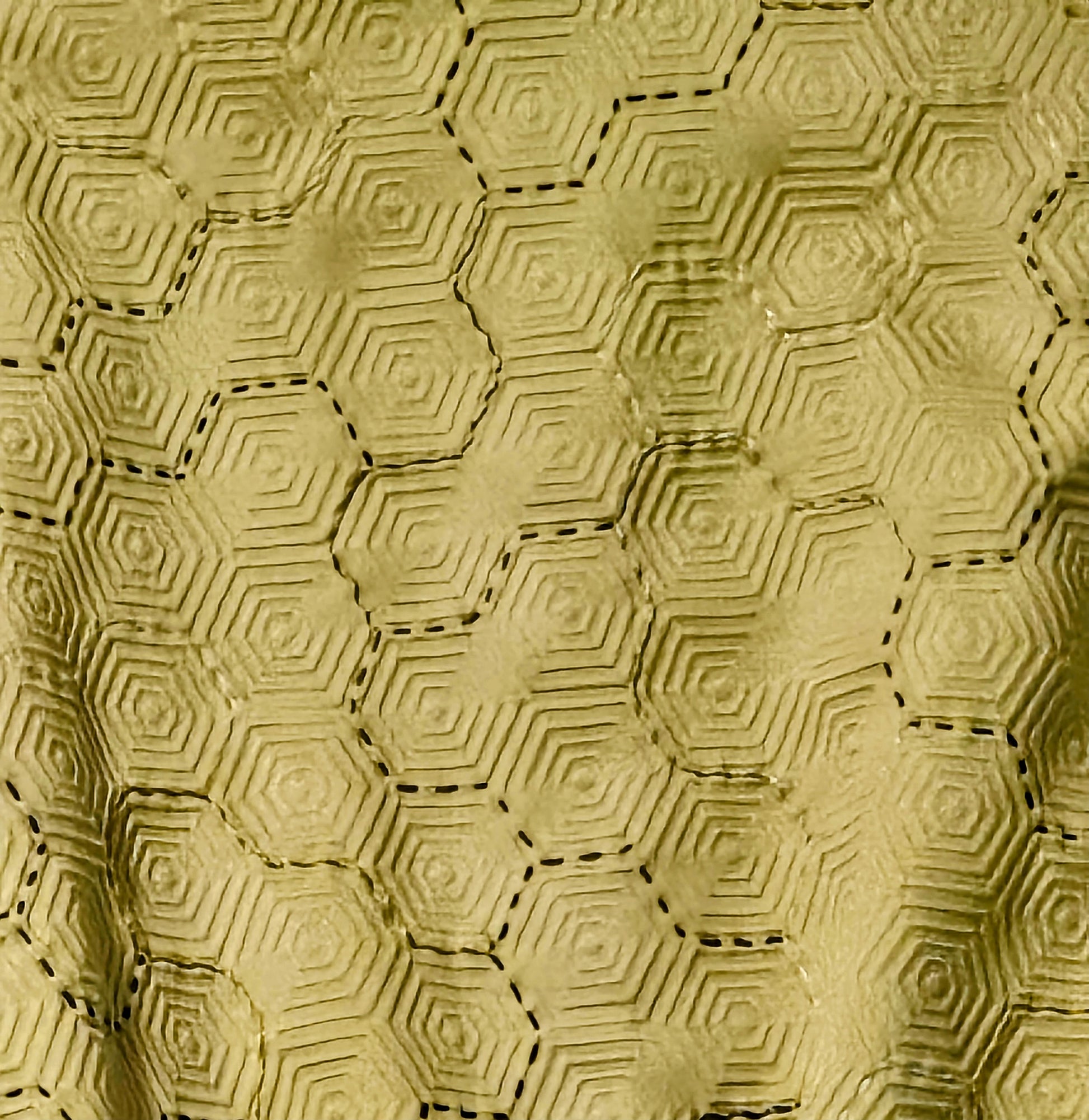 close up view of embroidery on Hand embroidered honeycomb print textured cropped bomber jacket with multi-coloured fur sleeves.