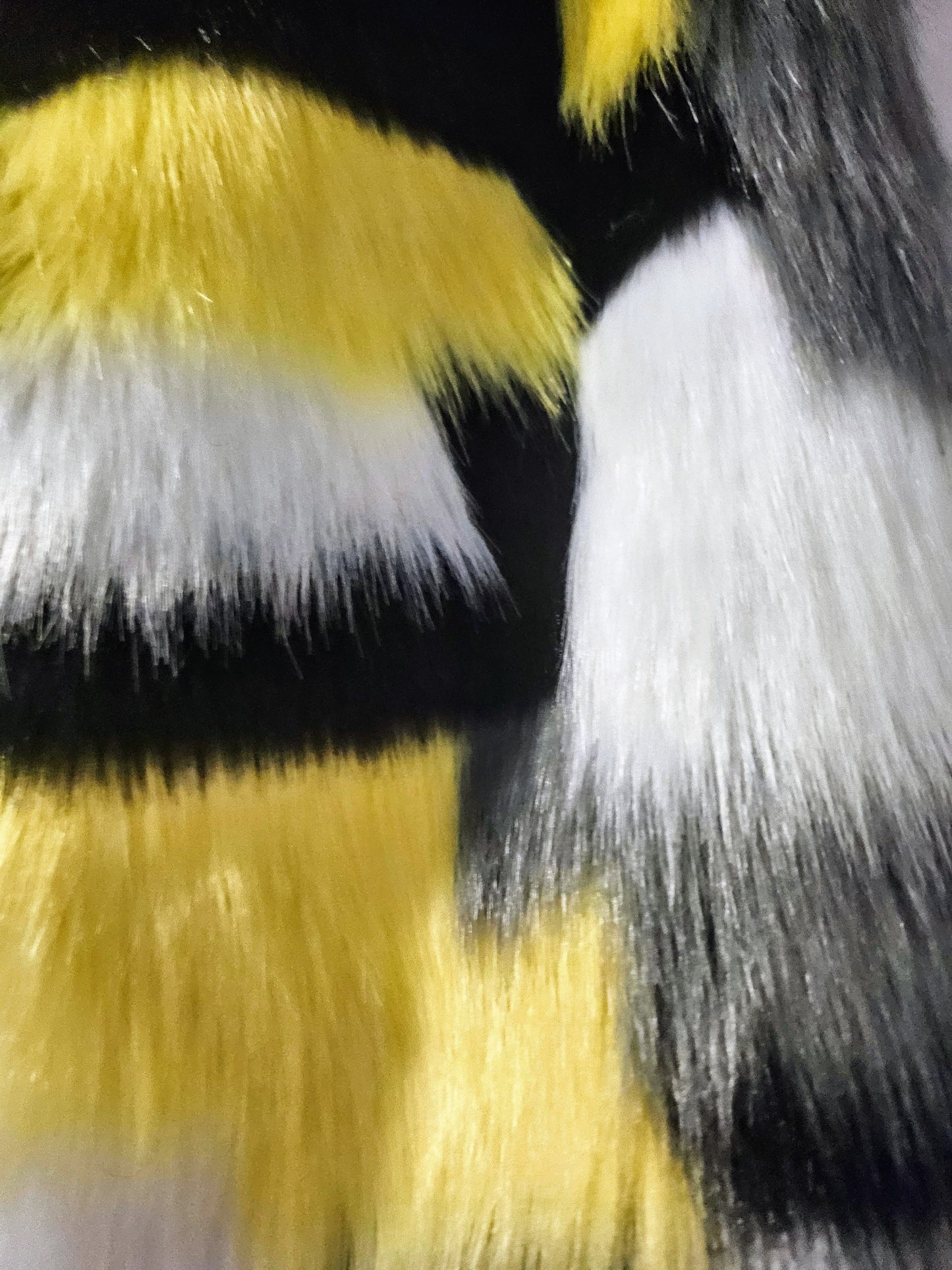 faux fur close up of Hand embroidered honeycomb print textured cropped bomber jacket with multi-coloured fur sleeves.