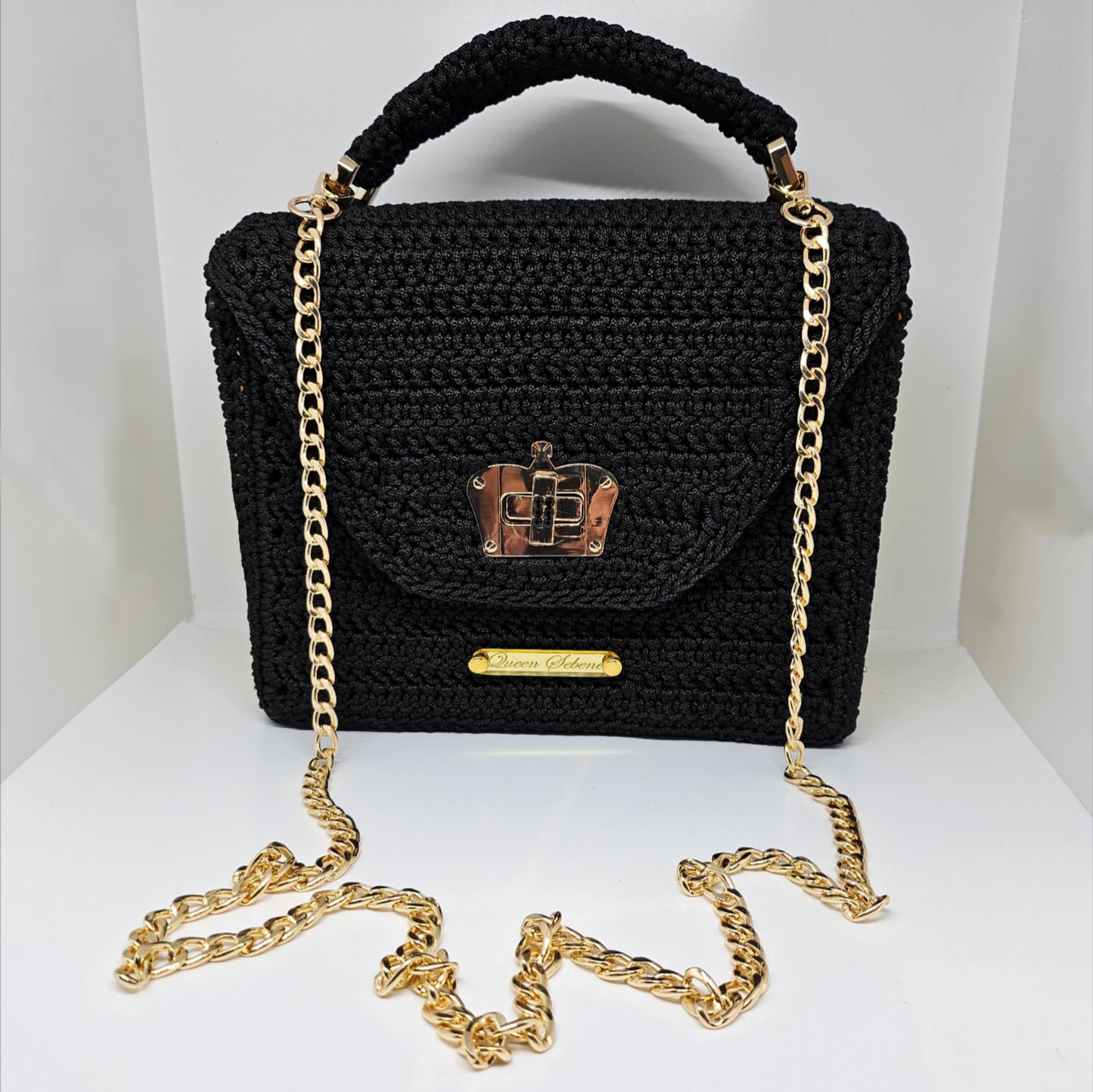 Front view with strap of Structured black crochet handbag with custom made laser cut acrylic sides