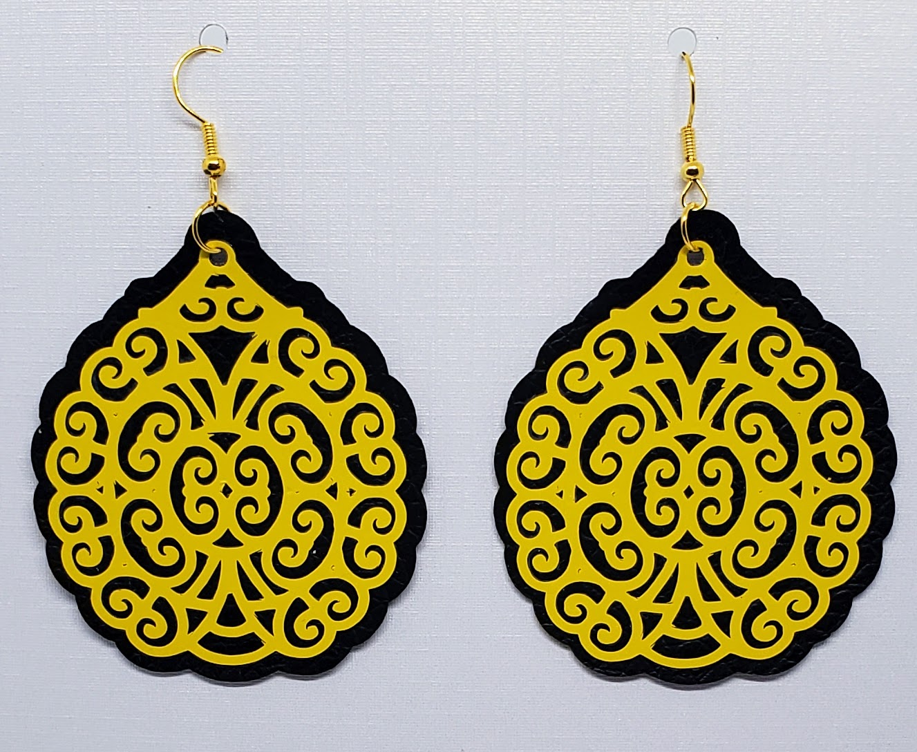 yellow on black filigree printed vinyl earrings.