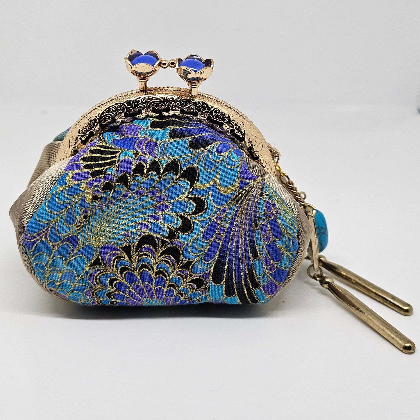 Front view of Peacock print kiss clasp coin purse with ornated jeweled tassel.