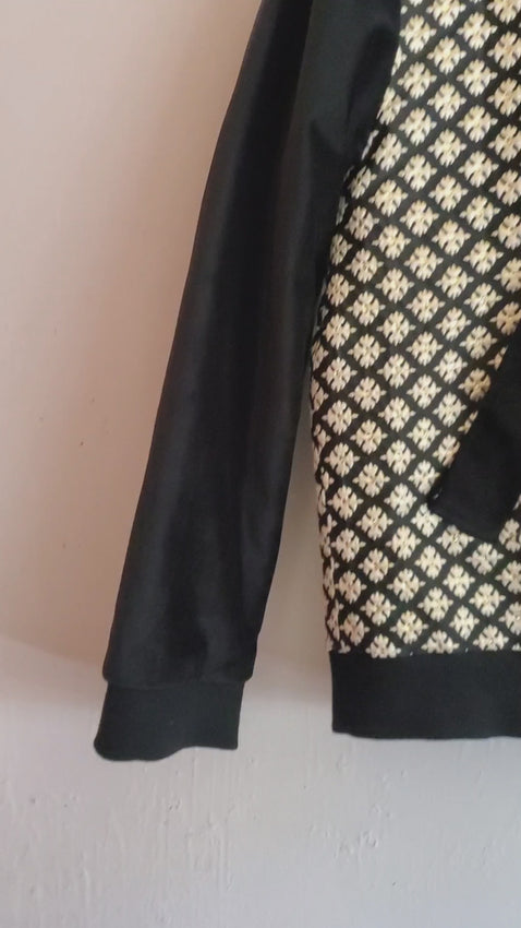Video of black and gold brocade bomber jacket on white background.