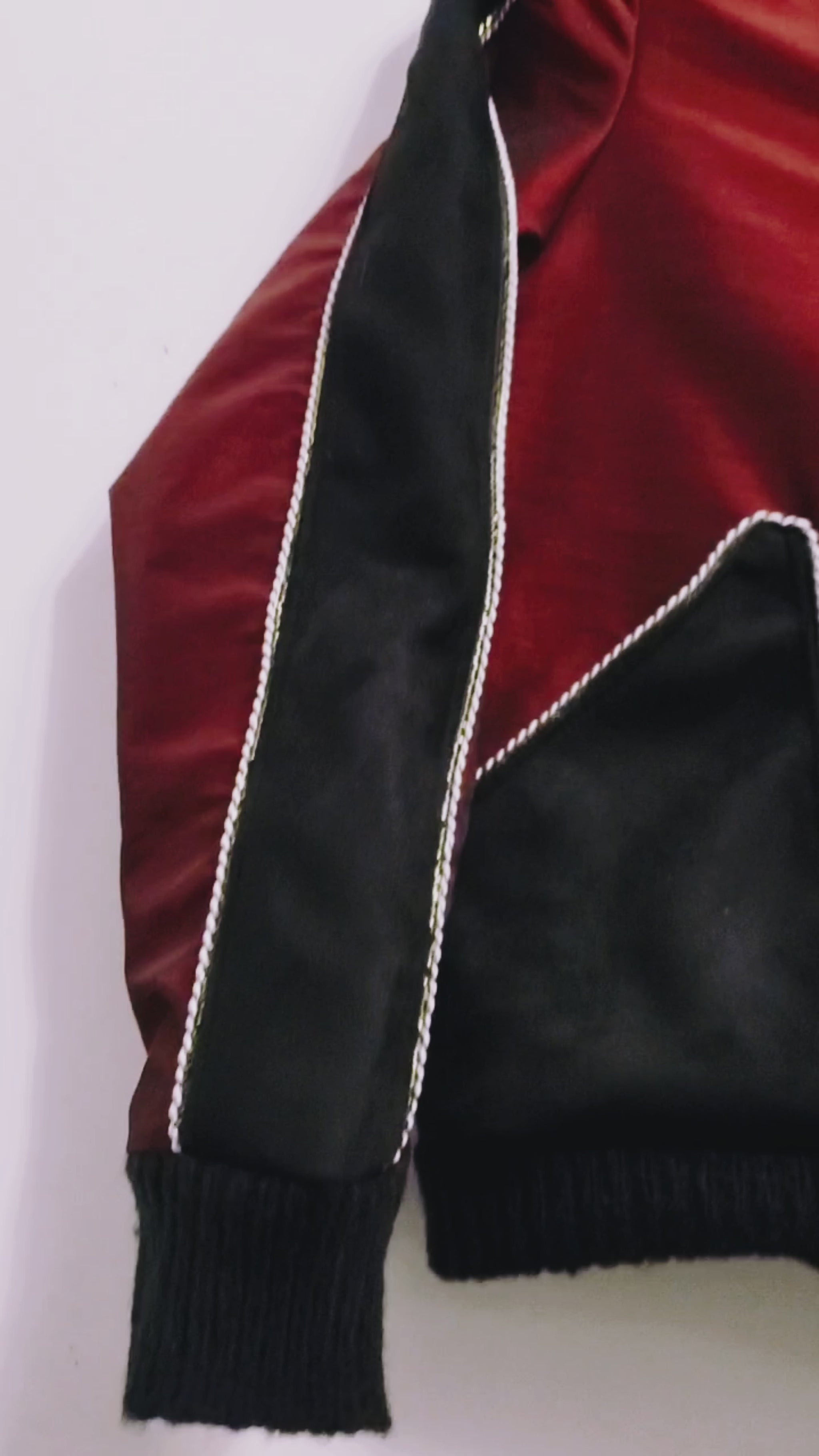 Video of red taffeta and black velveteen colour-blocked bomber jacket with white cord piping
