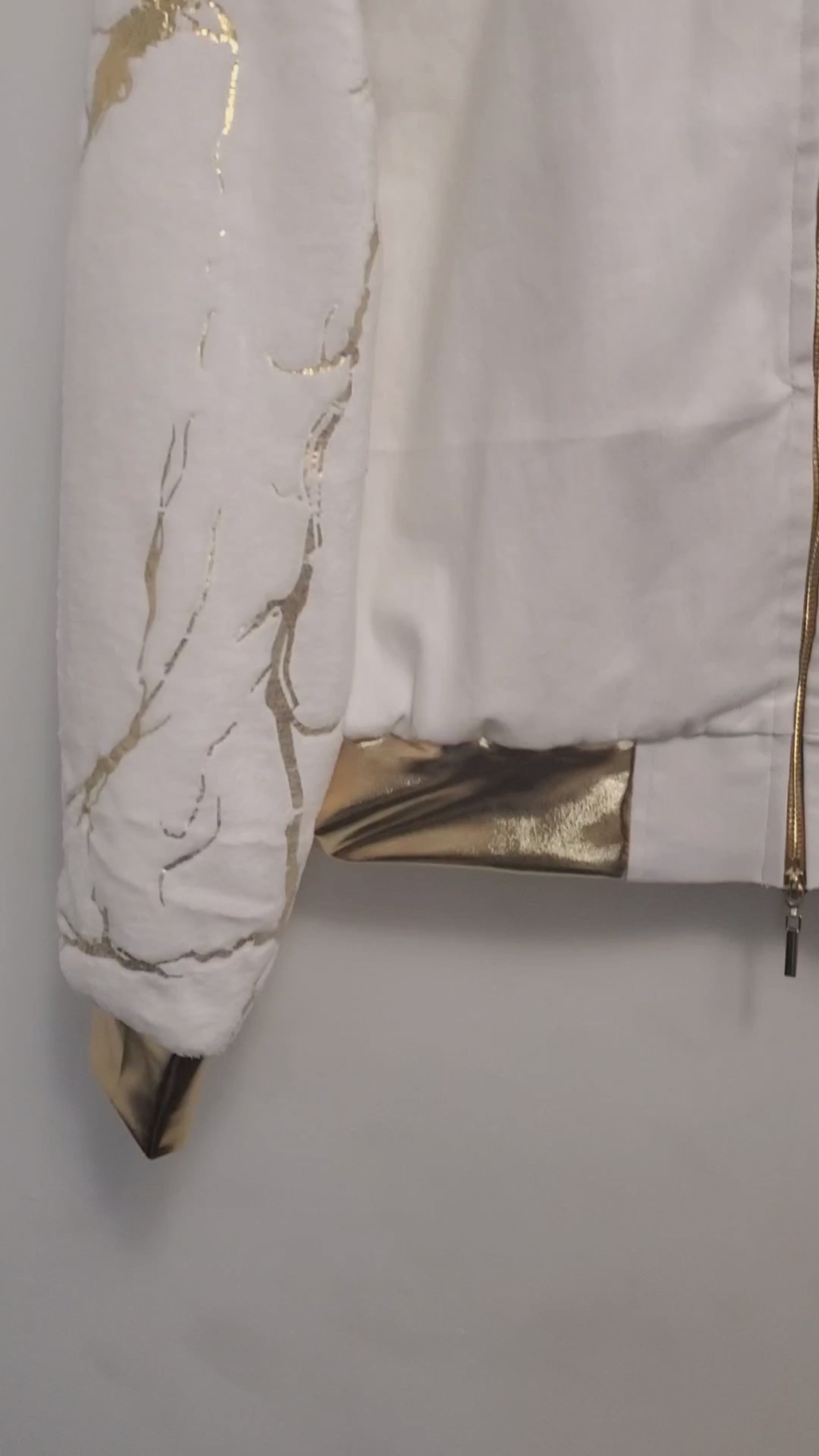 Video of White bomber with gold marble print sleeves