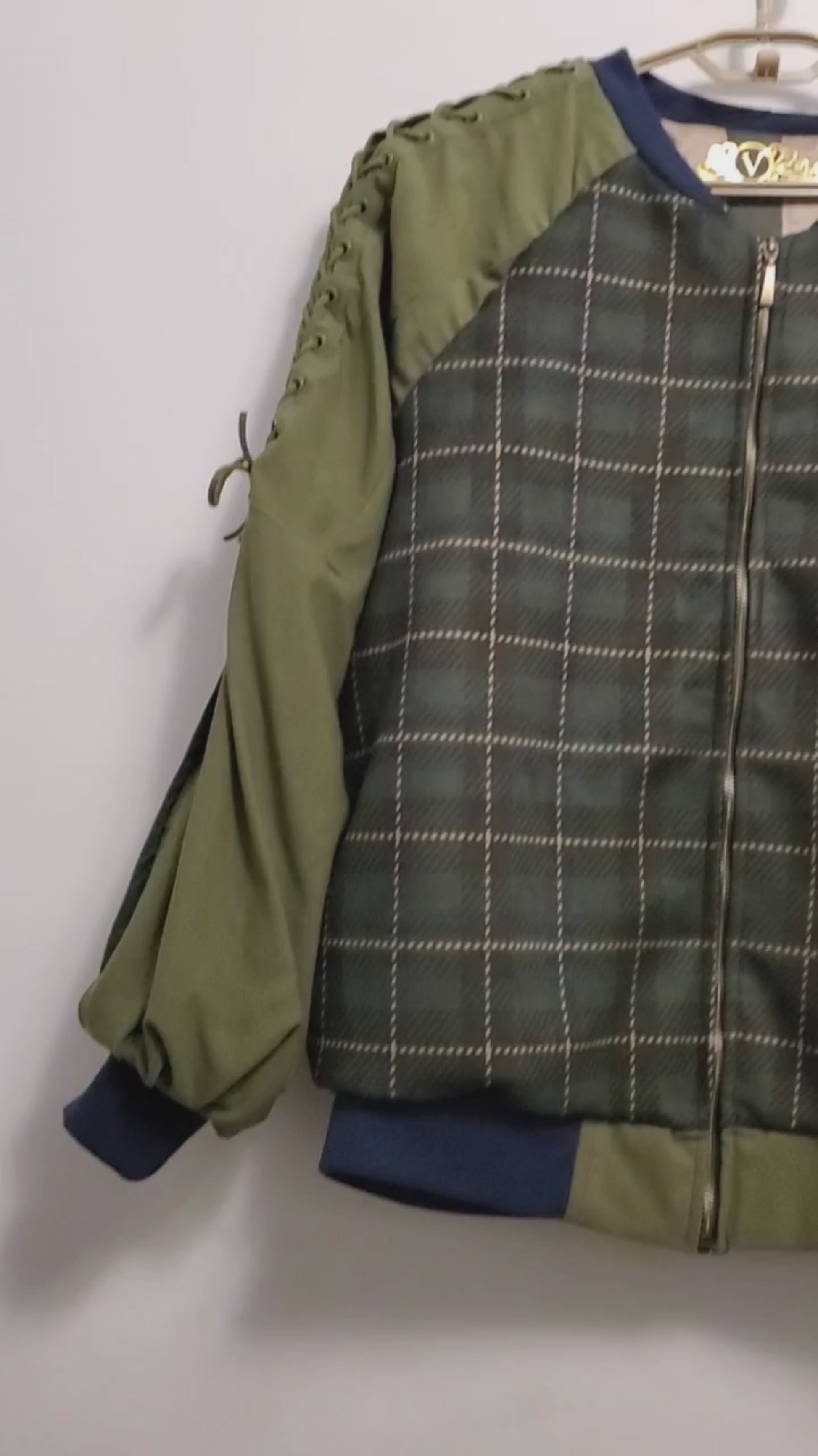 video of Forest green plaid bomber jacket with split sleeves and laced shoulder details.