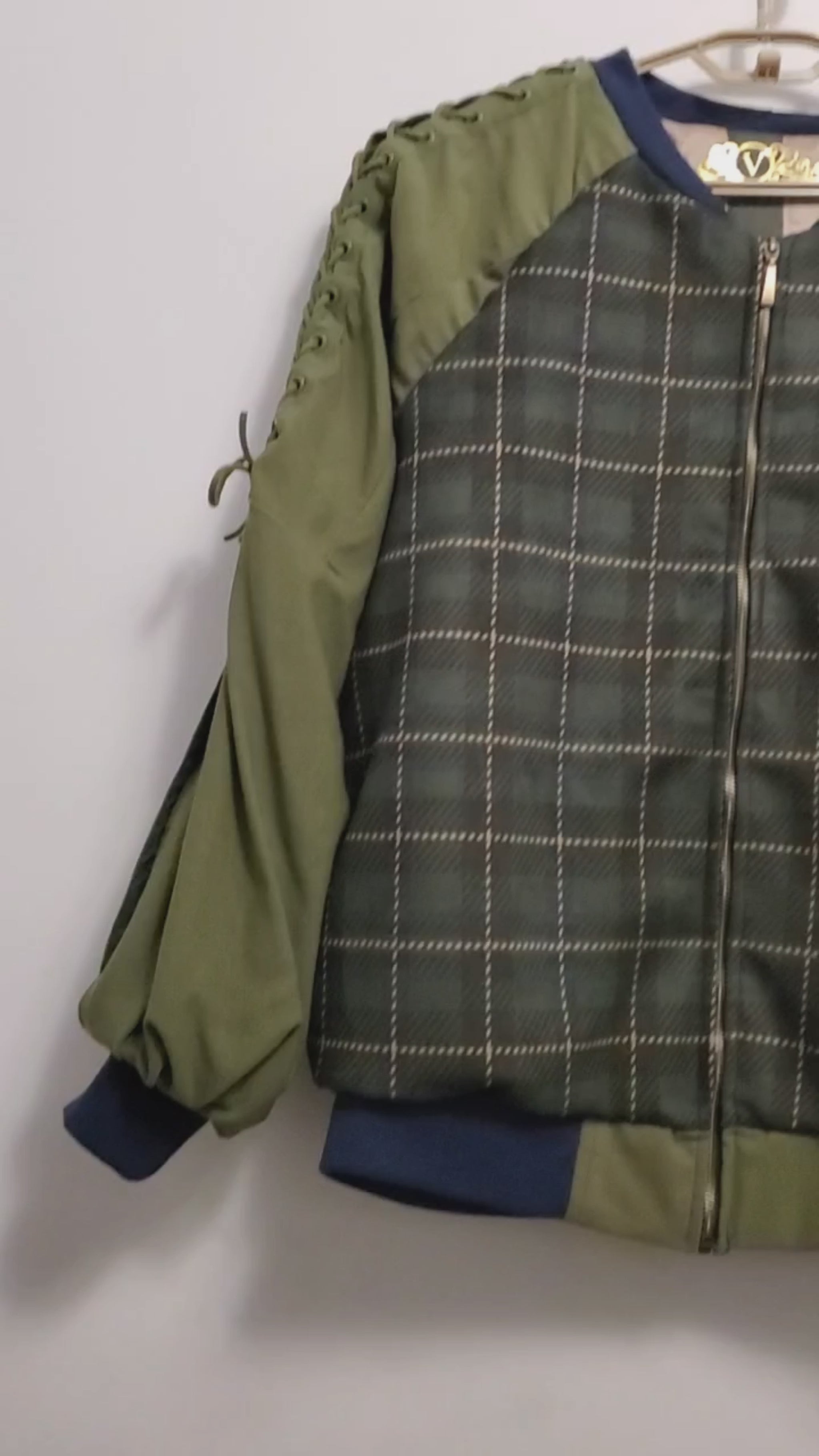video of Forest green plaid bomber jacket with split sleeves and laced shoulder details.