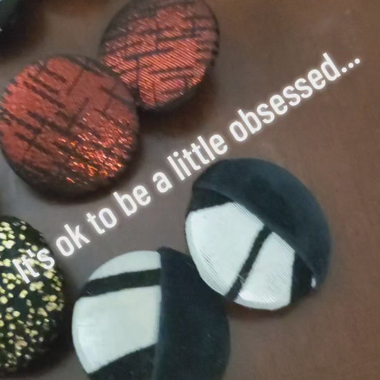Video of large button earrings displayed on table