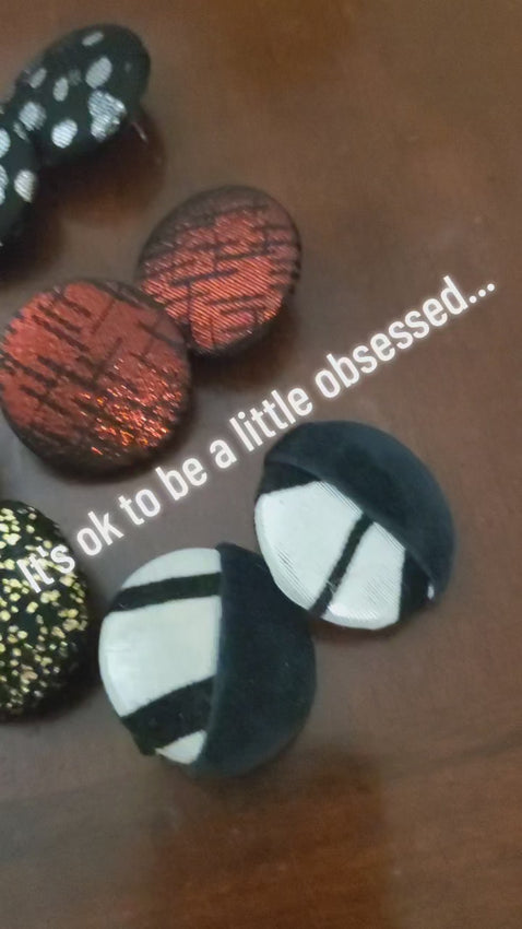 Video of large button earrings displayed on table