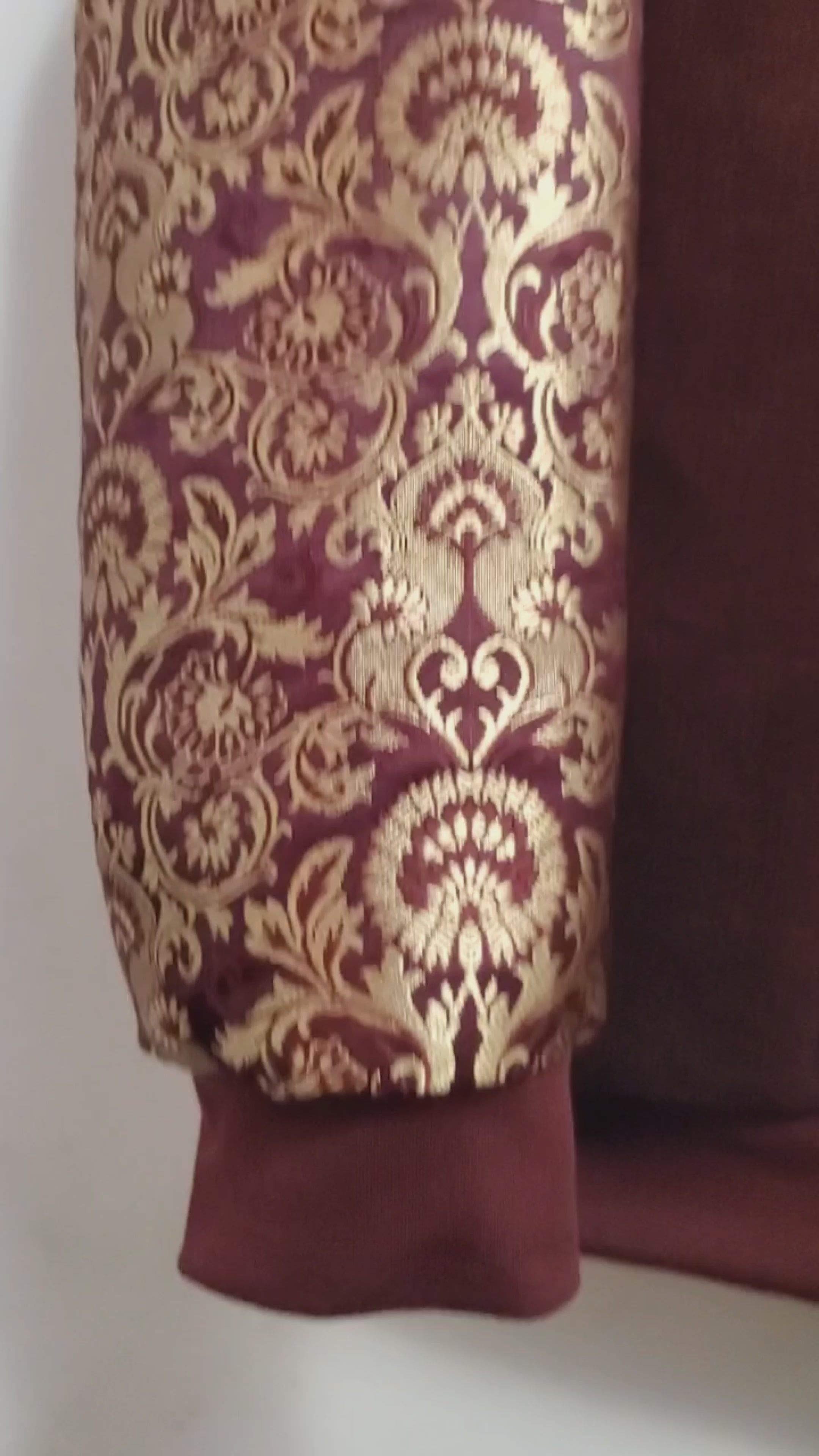 video of Burgundy corduroy bomber jacket with metallic gold sleeve and knot closures