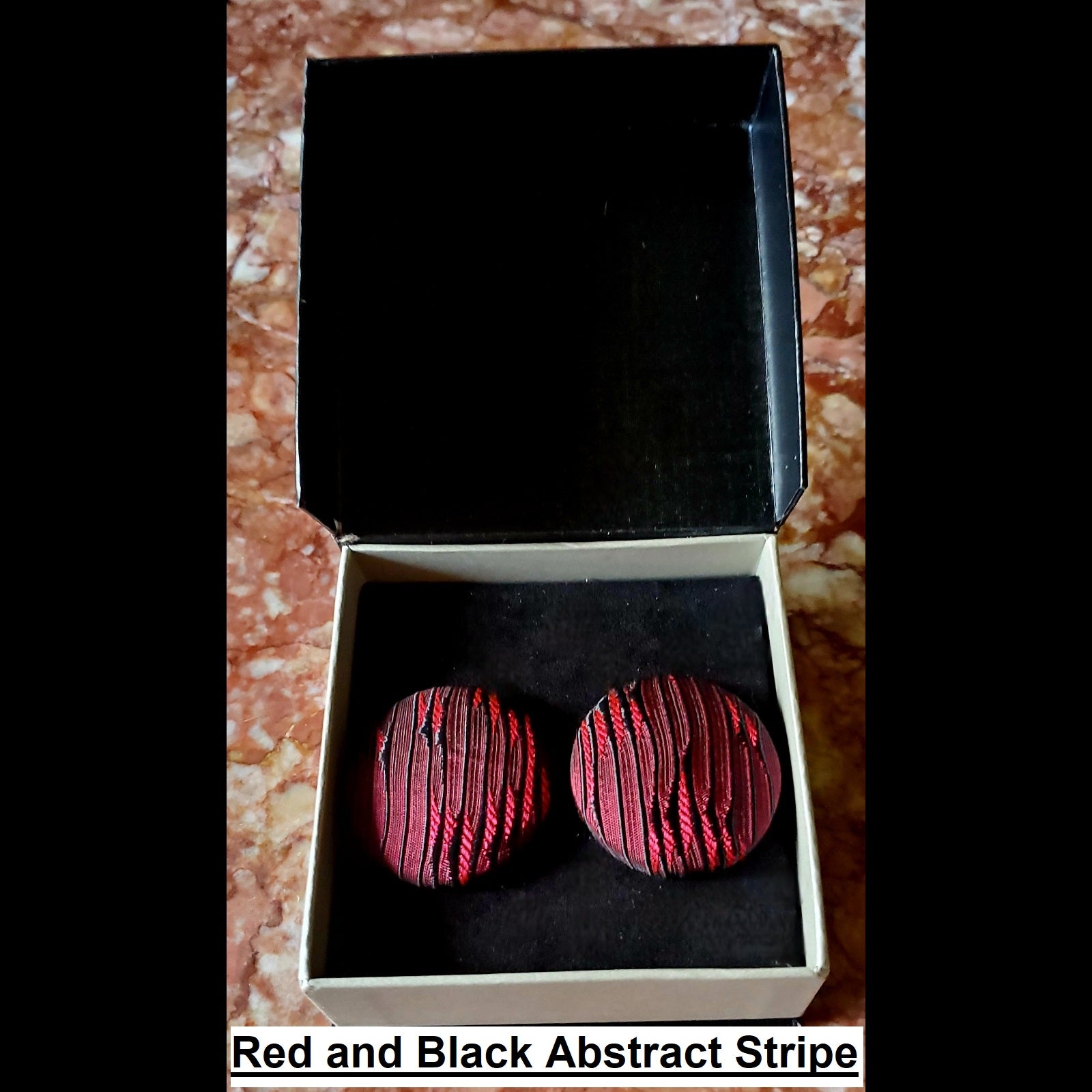 Red and black abstract stripe print button earrings in jewelry box