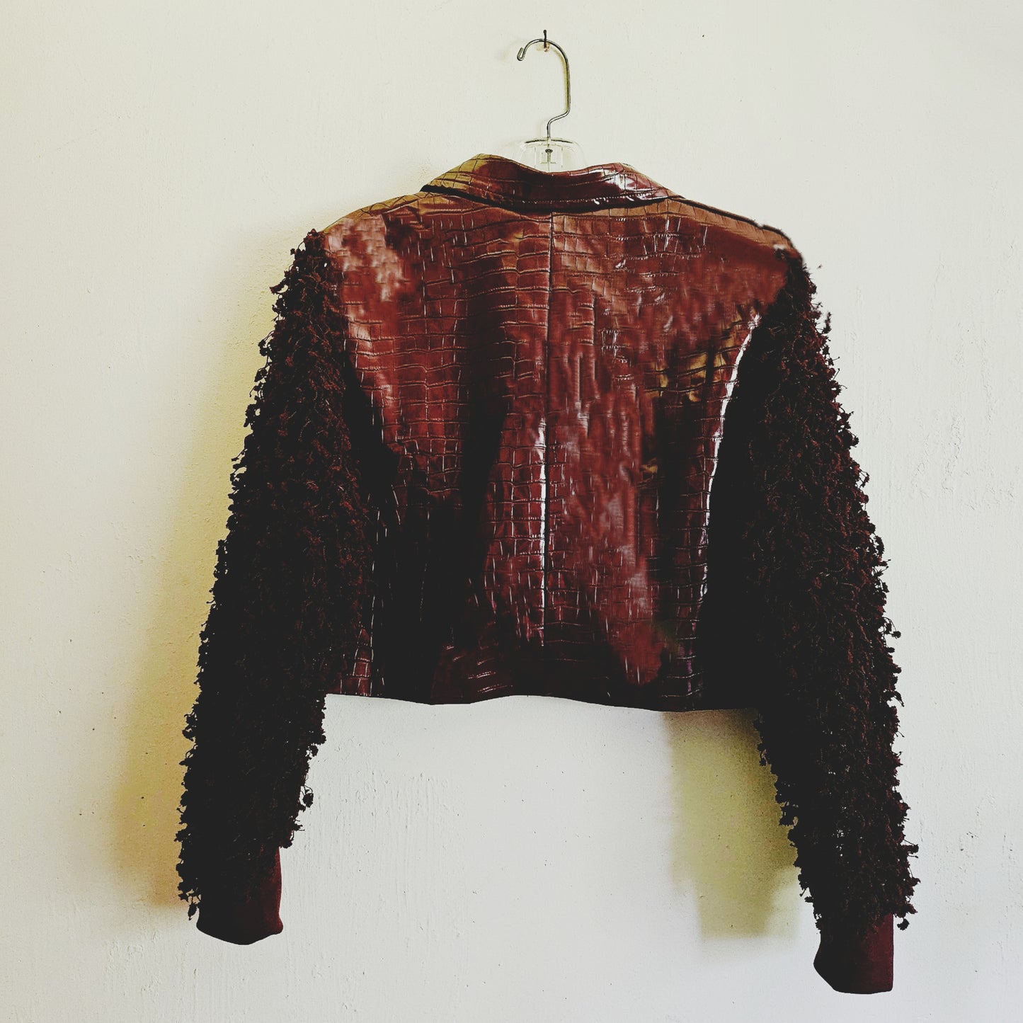 Back view of burgundy croc embossed cropped jacket with fringe knit sleeves