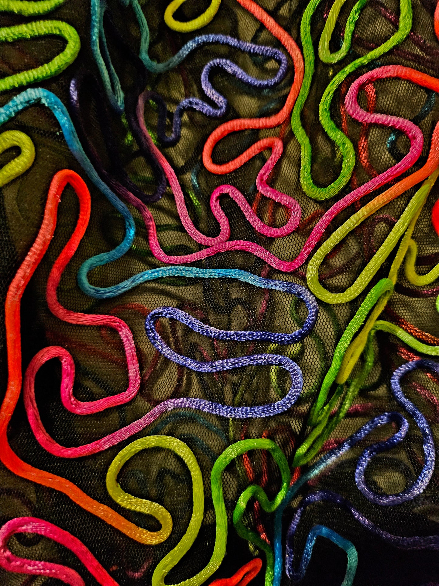 close up of the fabric of rainbow embroidered mesh bomber jacket