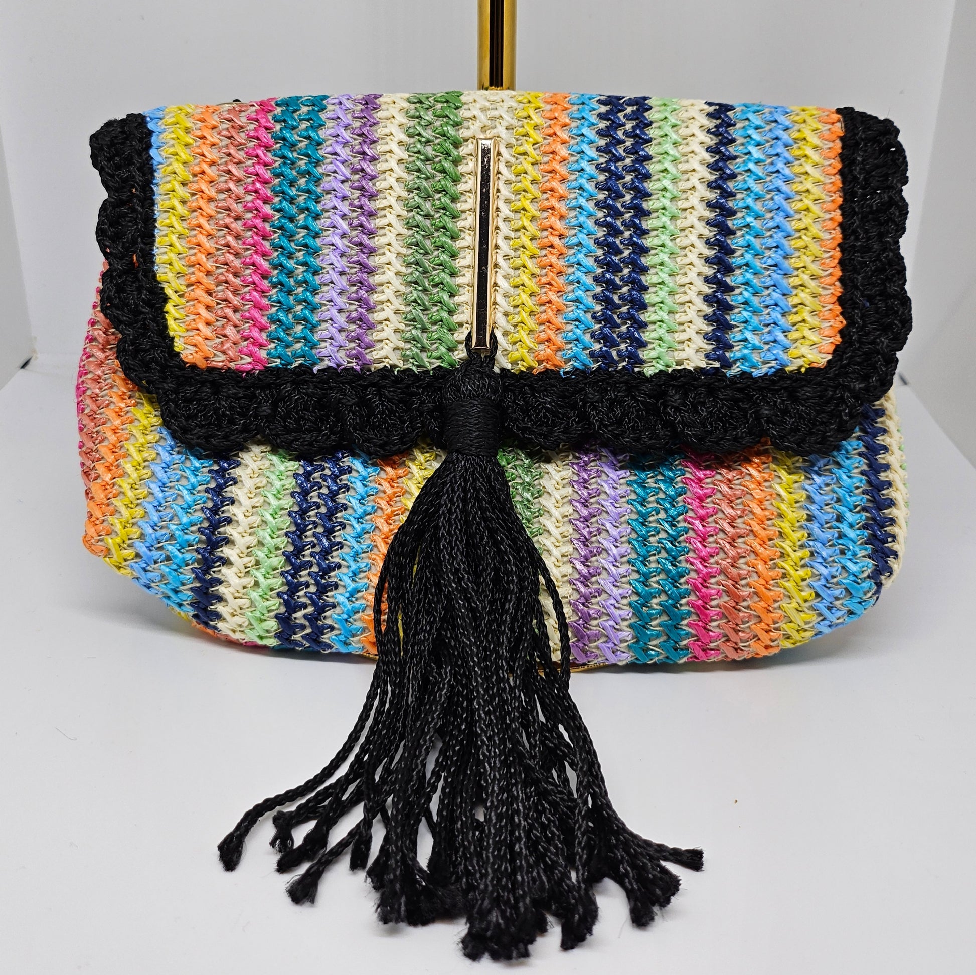 Front view of Rainbow striped crossbody with decorative tassel without strap 