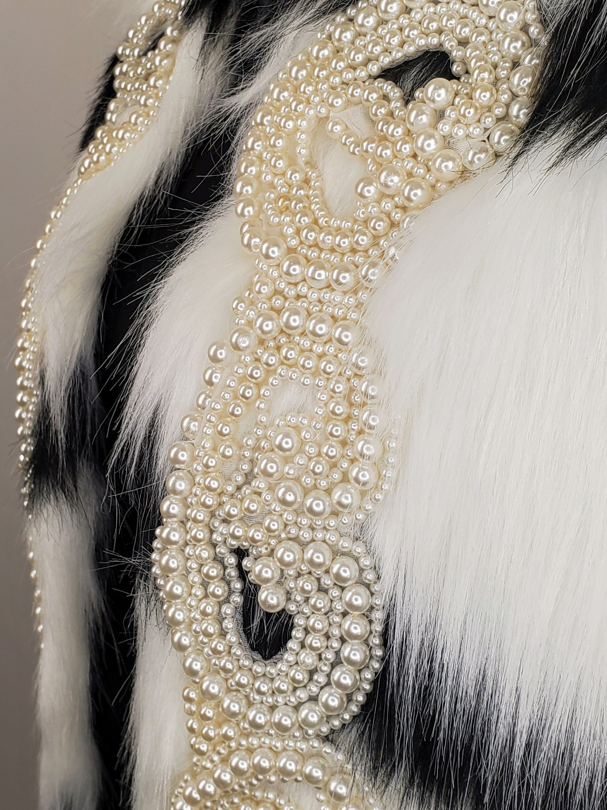 black and white faux fur coat with pearls closeup view