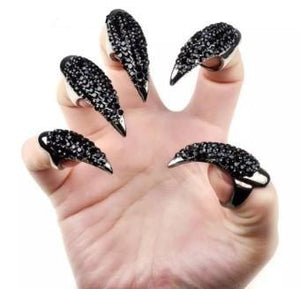 Silver and black rhinestone fingertip rings on fingers