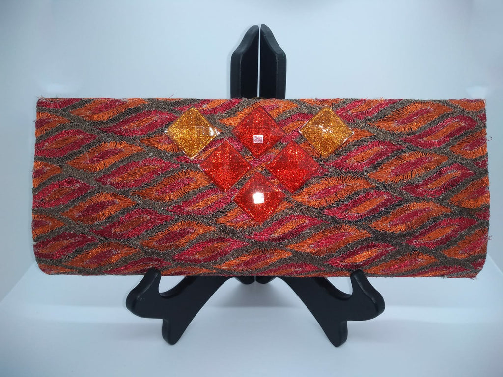 Orange clutch with square orange beads on stand